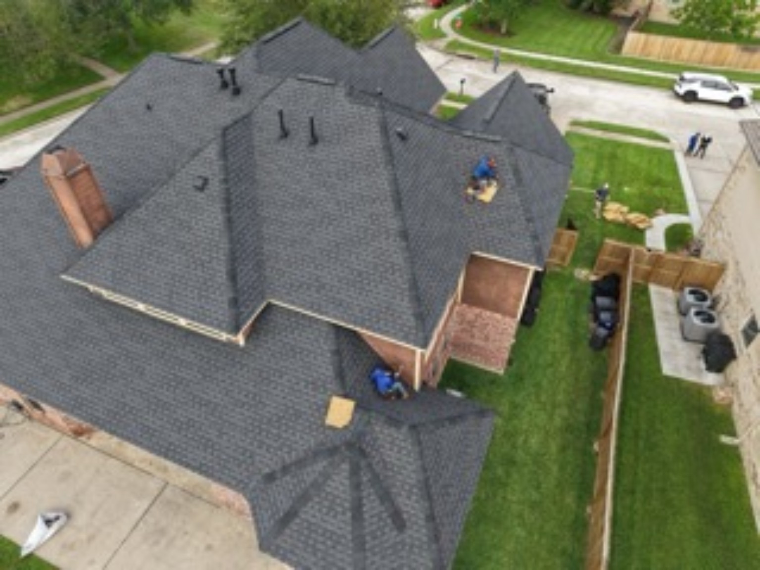 Roofing crew working on a residential shingle roof