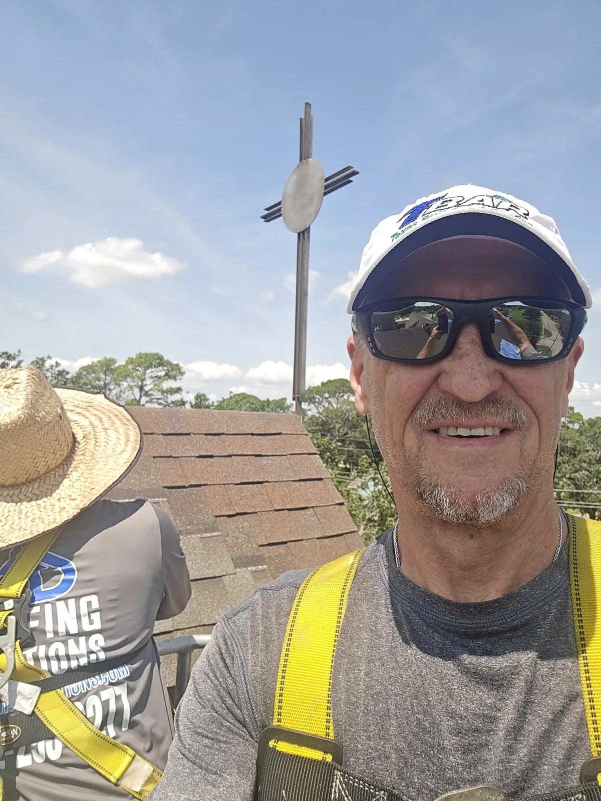 Owner, Tracy with crew person roofing the steeple area.